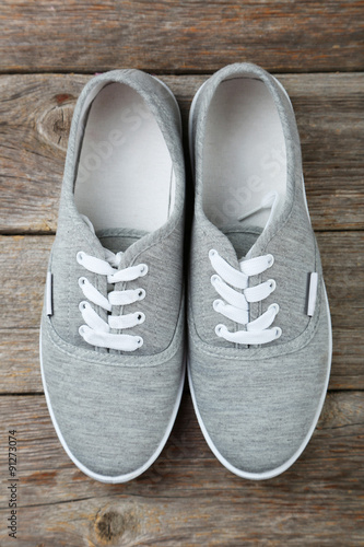 Pair of grey shoes on wooden background