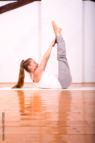 Woman practicing Yoga in a Studio.