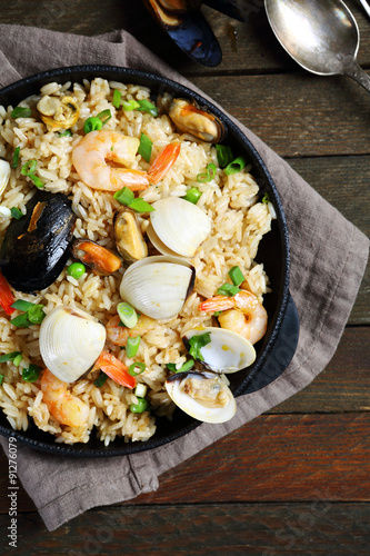 Paella with seafood and spices in pan