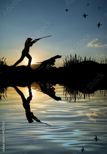 Silhouette of woman hunter at sunset. Duck hunting with dogs.