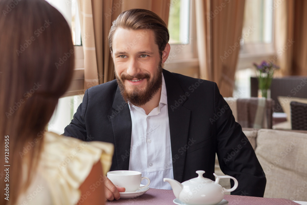 Cheerful young loving couple is meeting in cafe Cheerful young loving couple is meeting in cafe