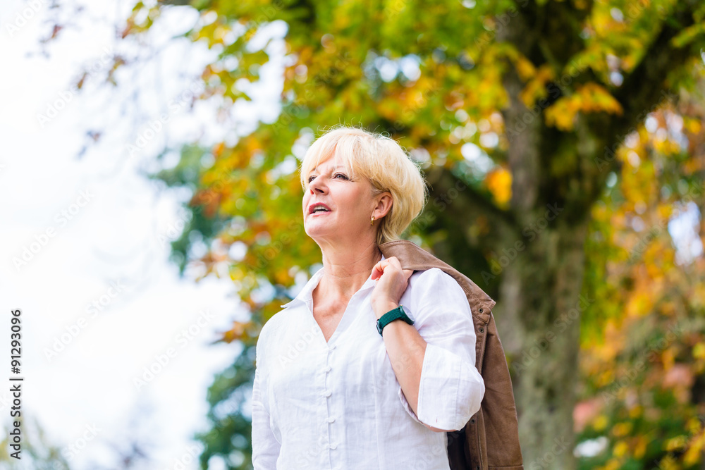 Senior Frau beim Spaziergang im Park Senior Frau beim Spaziergang im Park