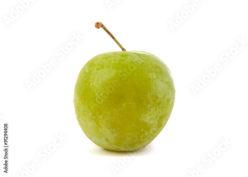 Close up of single green plum isolated on a white background
