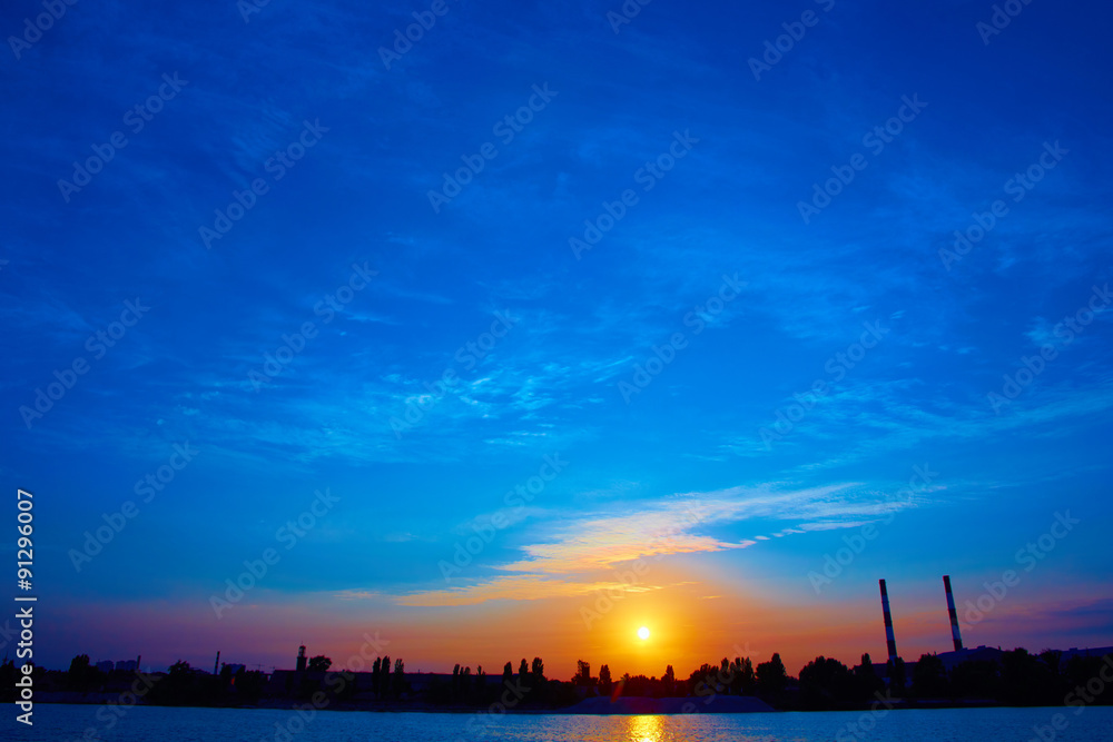 factory in silhouette and sunrise sky