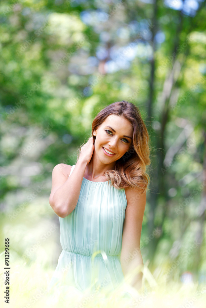 young woman in blue dress sitting on grass young woman in blue dress sitting on grass