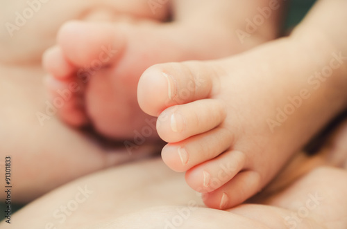 Baby's foot in mother hands, Soft and selective focus © VICHAILAO