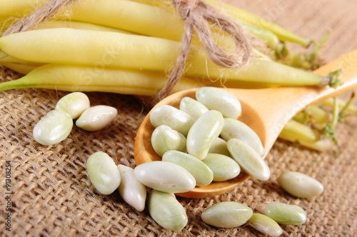 Seeds and stack of yellow beans on jute canvas, healthy food