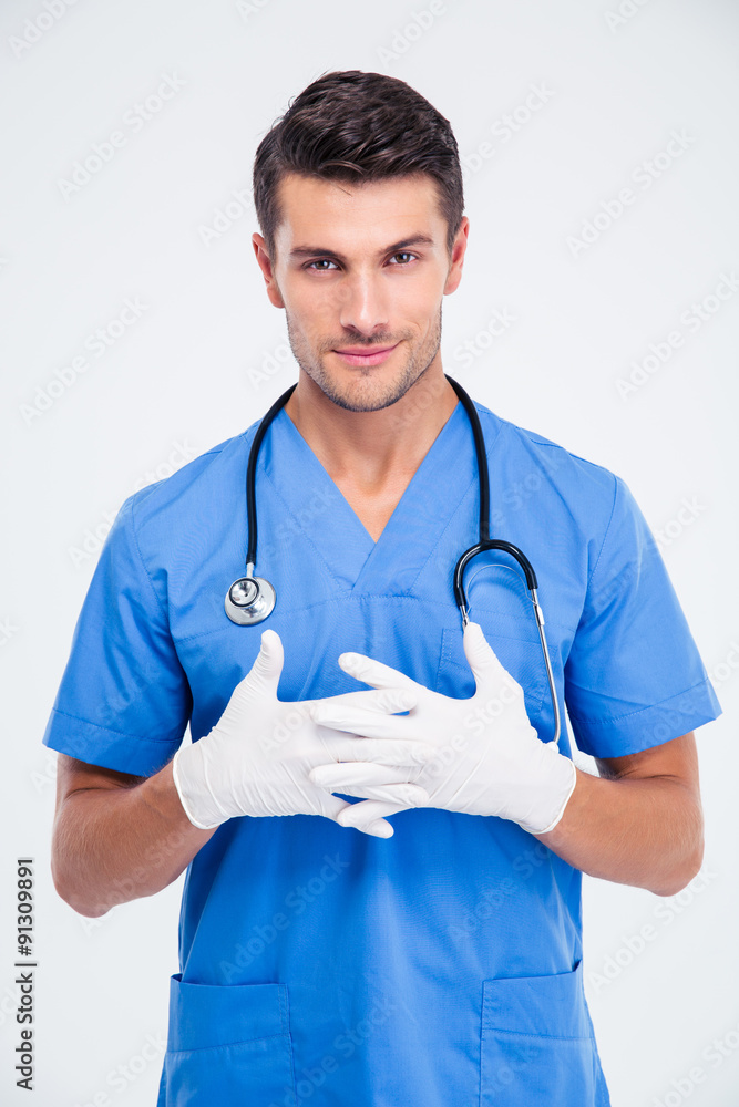 Smiling male doctor standing in medical gloves Smiling male doctor standing in medical gloves
