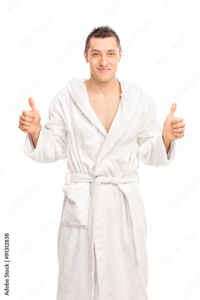Happy young man in a white bathrobe giving two thumbs up isolate Happy young man in a white bathrobe giving two thumbs up isolate