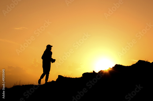 Silhouette of women walking on the mountain at sunset