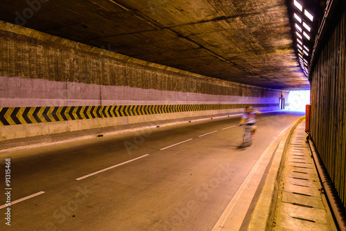 Motion blur of cyclist in underground road.