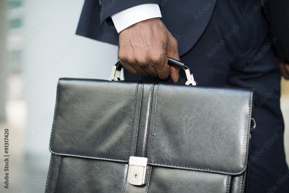Businessman holding his briefcase - obrazy, fototapety, plakaty 