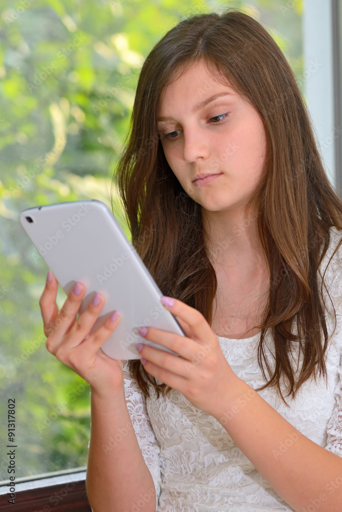 Young girl reading information on a tablet computer Young girl reading information on a tablet computer