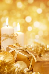 Christmas scene with gold baubles, gift and candles