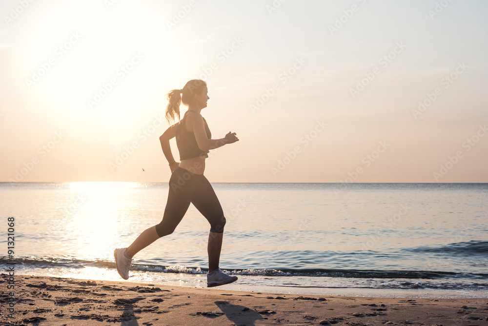 Running woman. Female runner jogging during the sunrise on beach.