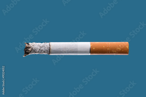 Cigarette burning on blue background