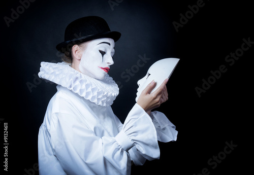 Foto Sad mime Pierrot looking at the mask