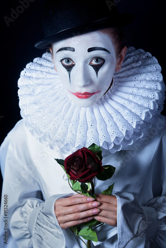 Sad mime Pierrot with a red rose photo