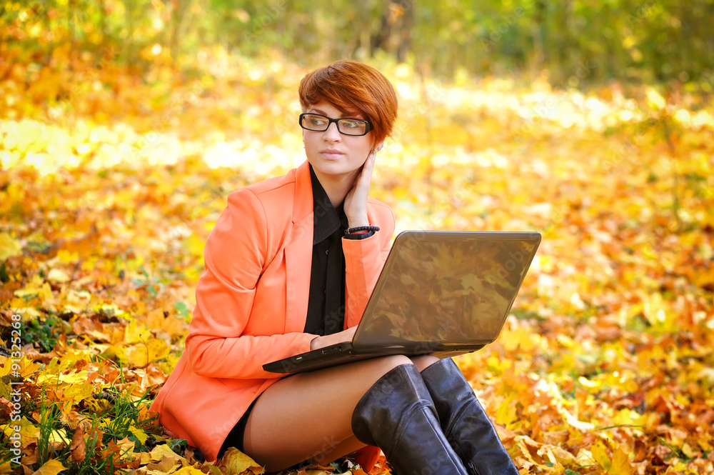 Cute woman with laptop in the autumn park Cute woman with laptop in the autumn park