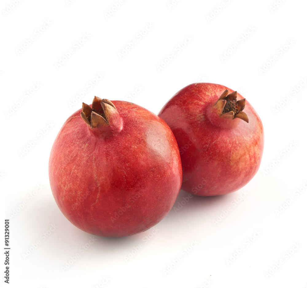 two pomegranates photographed on a white background with a soft two pomegranates photographed on a white background with a soft