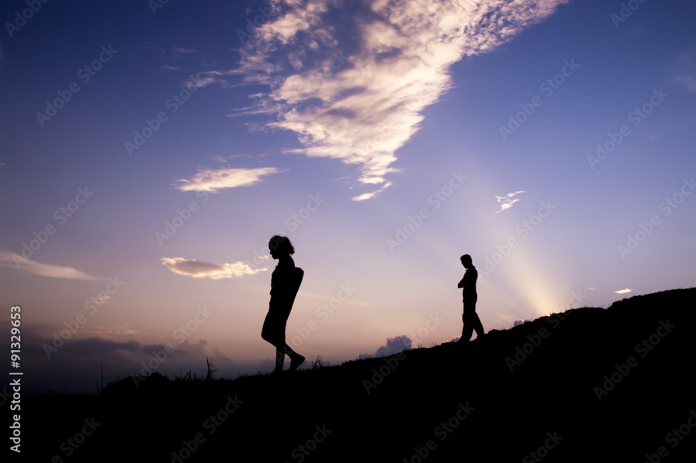 Silhouette of traveler walking on the hill at sunset