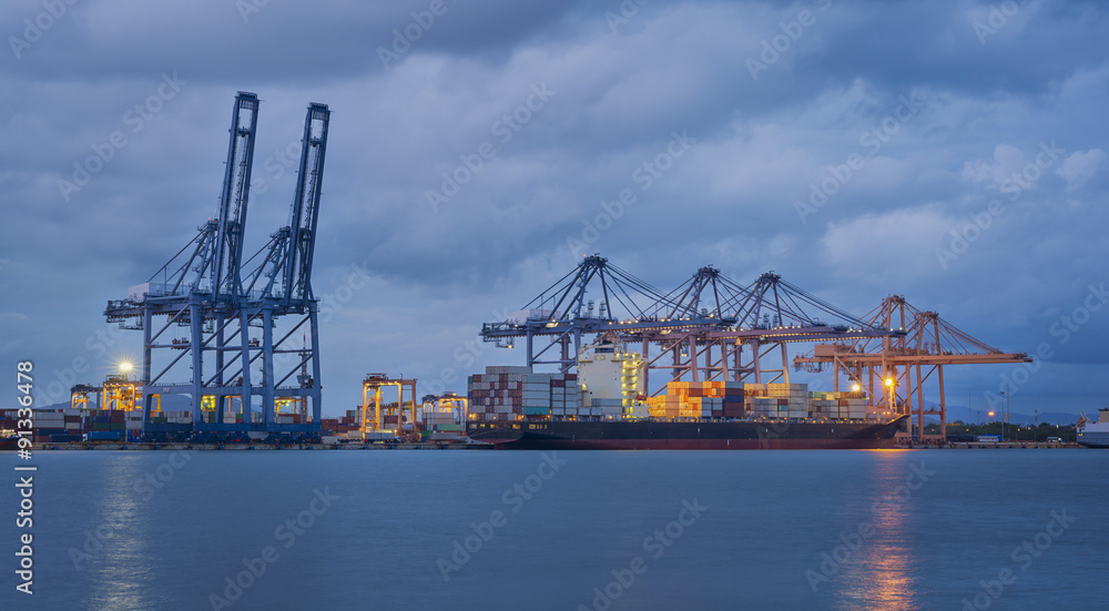 Container Cargo freight ship with working crane bridge in shipyard at dusk for Logistic Import Export background