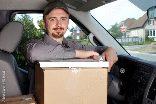 Young delivery man in the car.