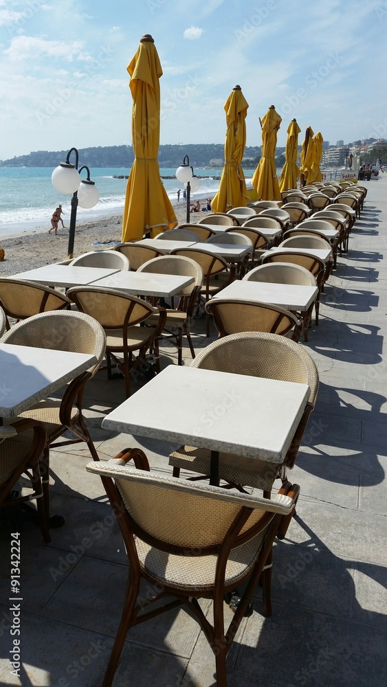 Obraz premium Tables et chaises alignées en bord de mer