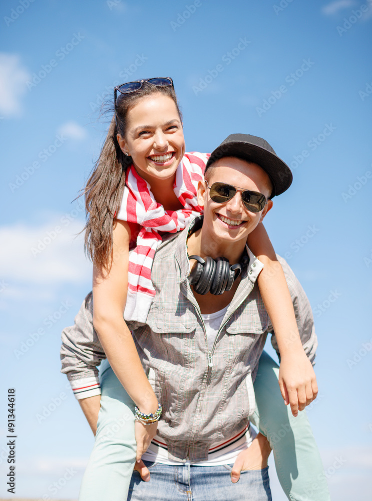 smiling teenagers in sunglasses having fun outside