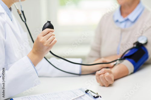 doctor with tonometer and senior woman at hospital