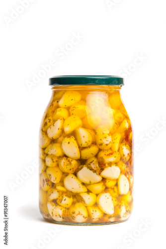 Vaso di vetro con spicchi d’aglio isolato su sfondo bianco