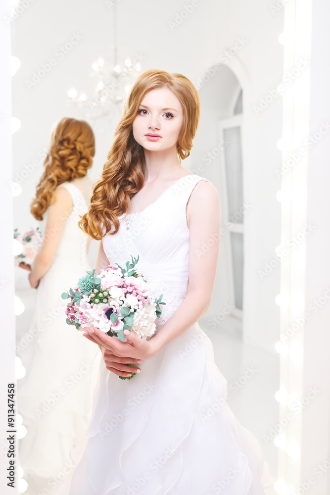 The girl in a wedding dress with a bouquet of flowers.