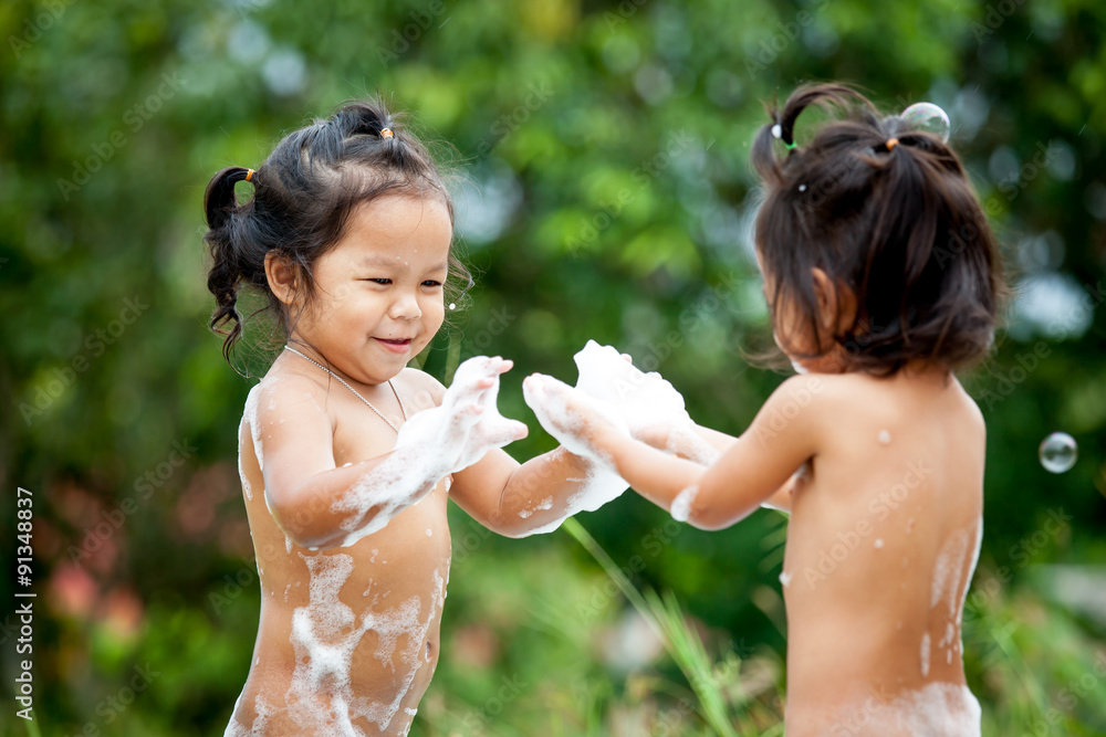 Two little girls having fun to play with water foam and bubble Stock Photo Adobe Stock