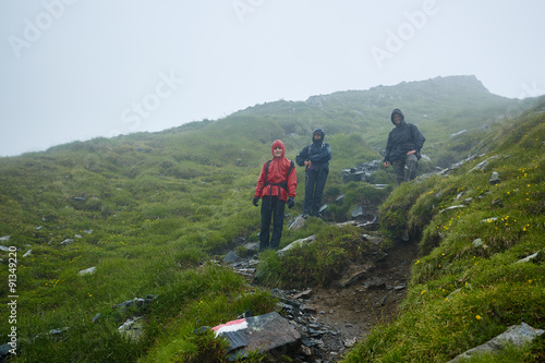 Hikers in raincoats on mountain © Xalanx