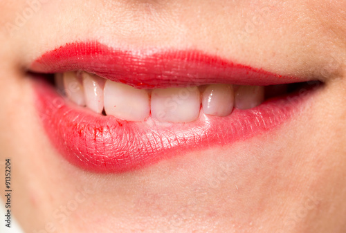 Close-up shot of woman lips with glossy red lipstick