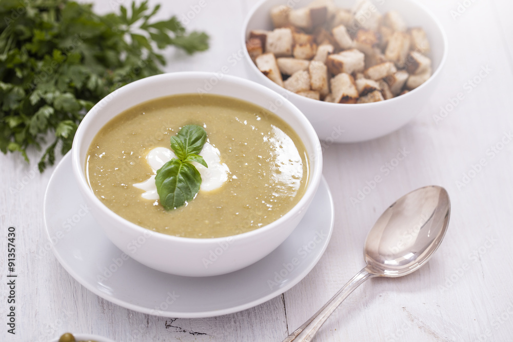 A delicious pea cream with aromatic spices on a wooden table. A delicious pea cream with aromatic spices on a wooden table.