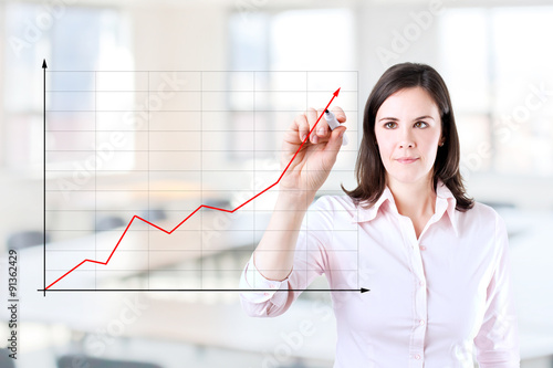 Young businesswoman writing on glass board or working with virtual screen 2. Office background.