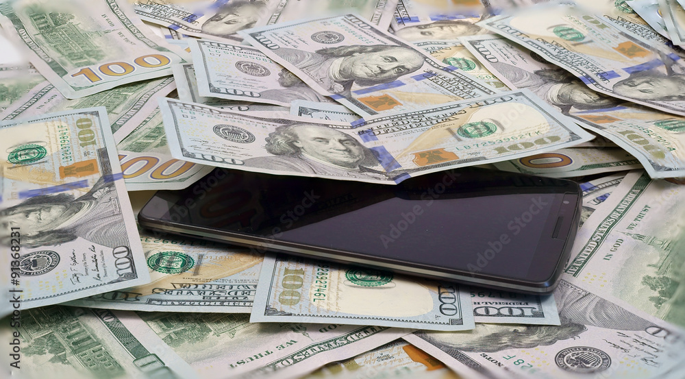 smartphone on dollar bills in american currency smartphone on dollar bills in american currency