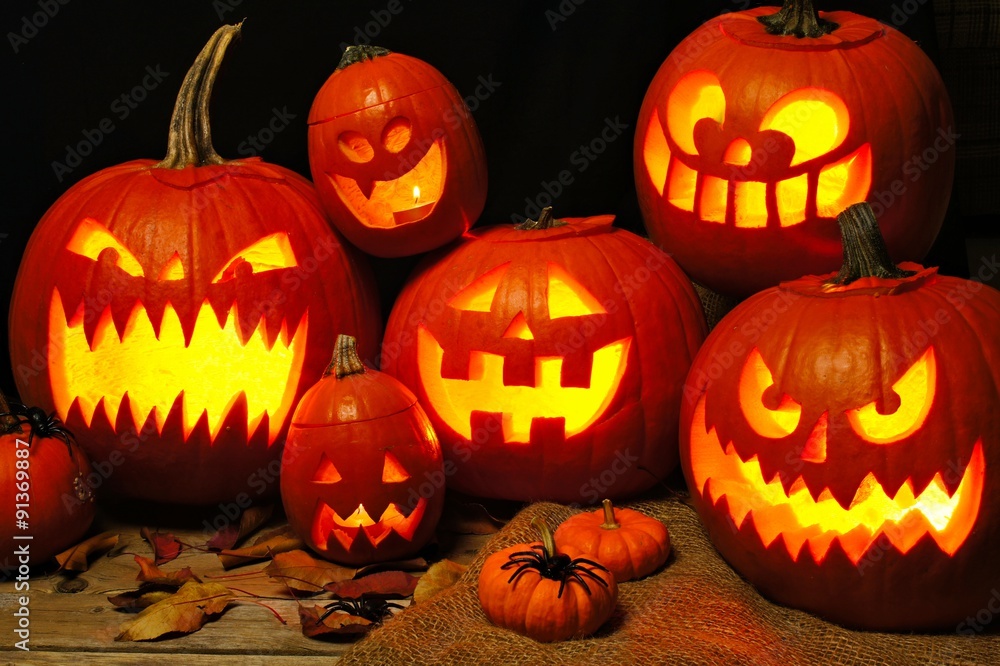 Halloween night scene with a group of spooky illuminated Jack o Lanterns Halloween night scene with a group of spooky illuminated Jack o Lanterns