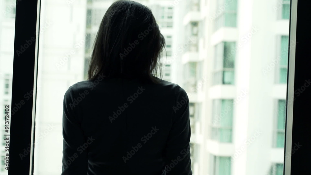 Young businesswoman unveil curtain and looking out of window
Young businesswoman unveil curtain and looking out of window
