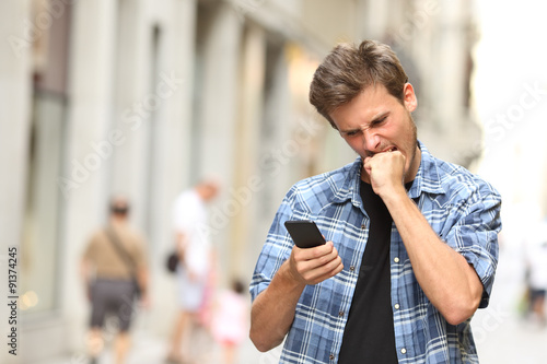 Konstfotografi furious angry man watching mobile phone