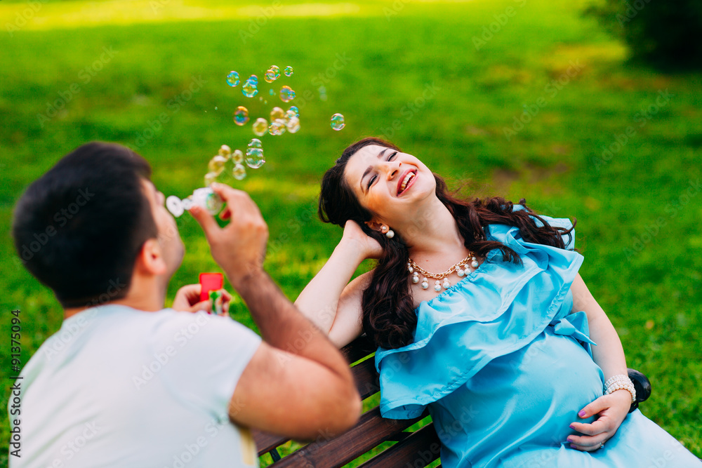 Beautiful pregnant couple relaxing outside in the park. Beautiful pregnant couple relaxing outside in the park.