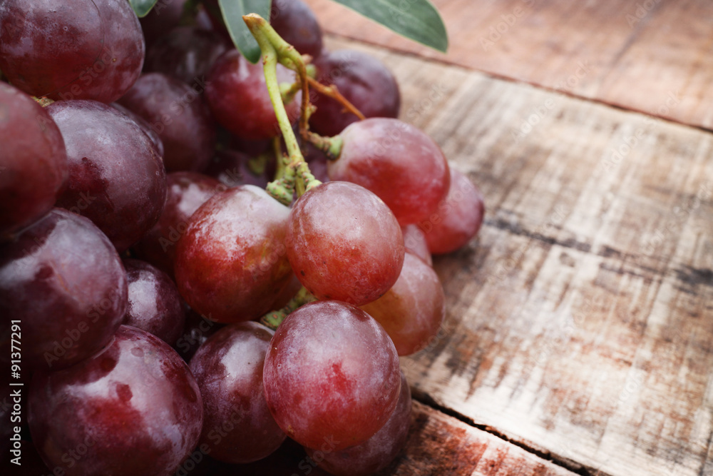 Bunch of red grapes on wooden table Bunch of red grapes on wooden table
