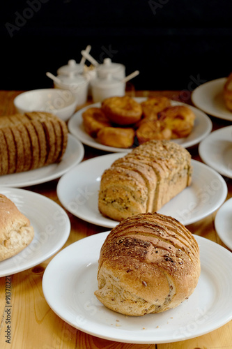 Baked bread on white plate and wooden table with Selective focus.