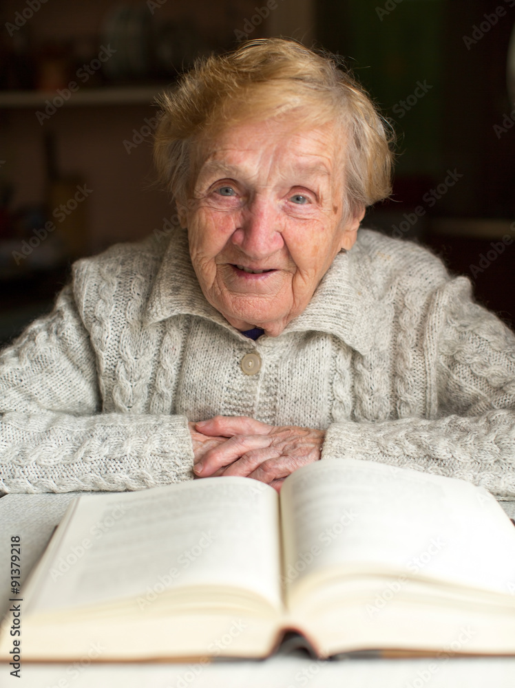 Portrait of Old woman reading a book sitting at the table. Portrait of Old woman reading a book sitting at the table.