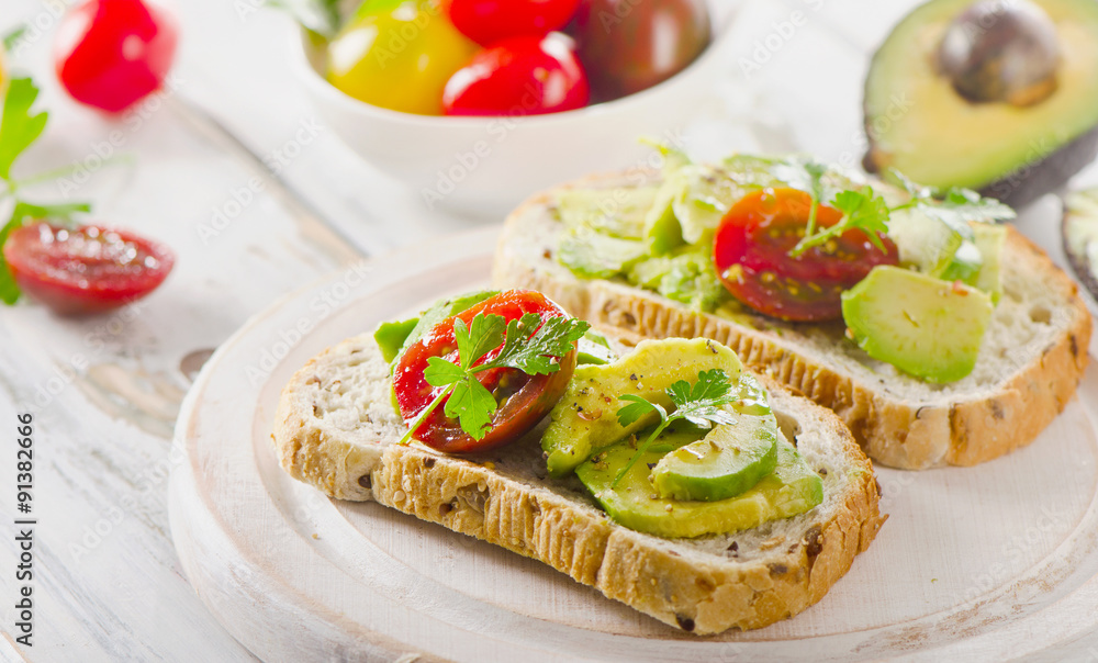 Homemade sandwiches with sliced avocado and tomato.
