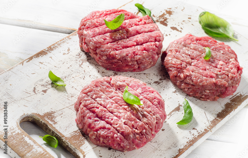 Raw Ground beef Burger steak patties on a wooden cutting board. Raw Ground beef Burger steak patties on a wooden cutting board.
