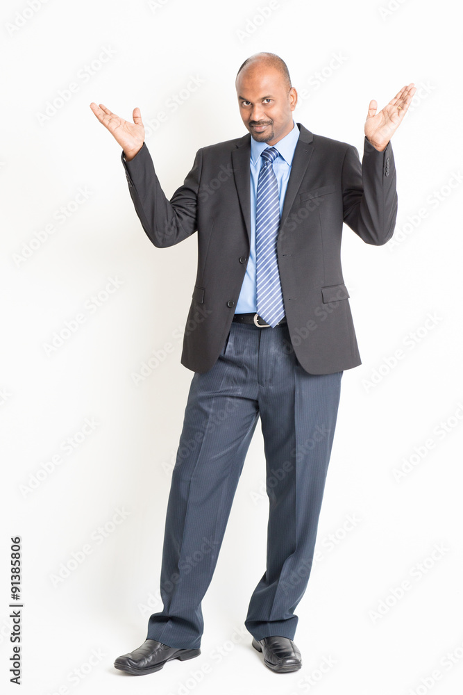 Full body mature Indian businessman open arms and showing someth Full body mature Indian businessman open arms and showing someth