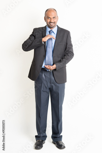 Full length mature Indian businessman holding something