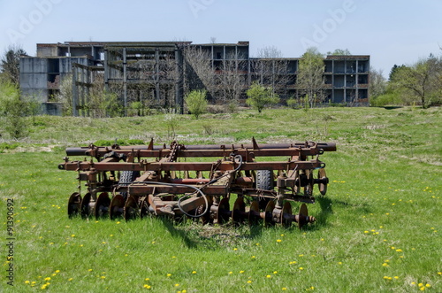 Abandoned unfinished building and farm machinery, harrow, Bulgaria 